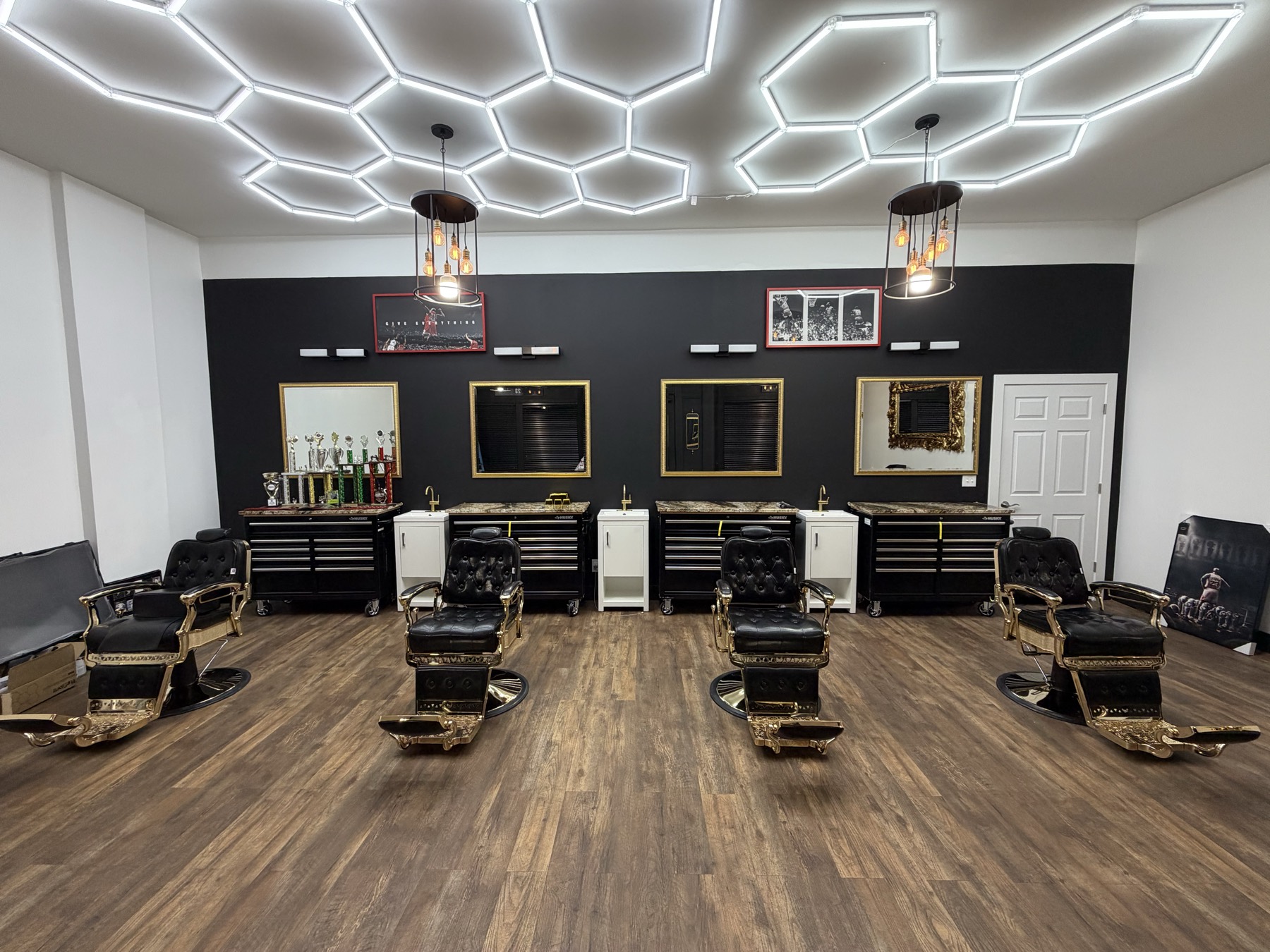 X Express Barbershop Studio interior — barber chairs, gold mirrors, and dark wood floor